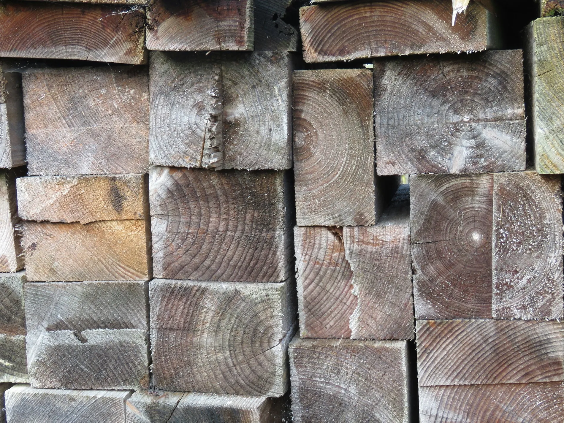 Weathered structural timber stacked in a yard