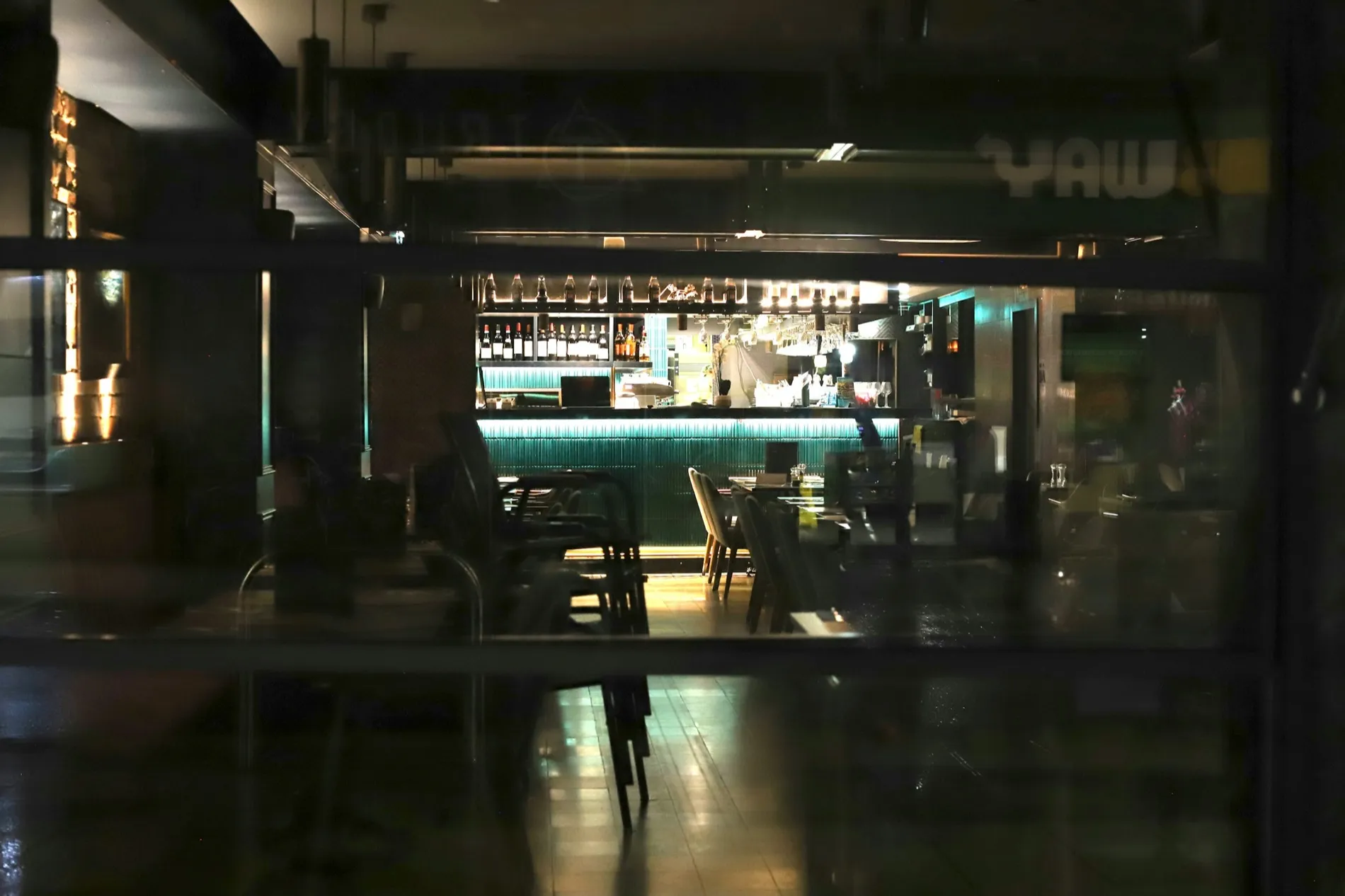 A bar counter lit from within in an otherwise dark room