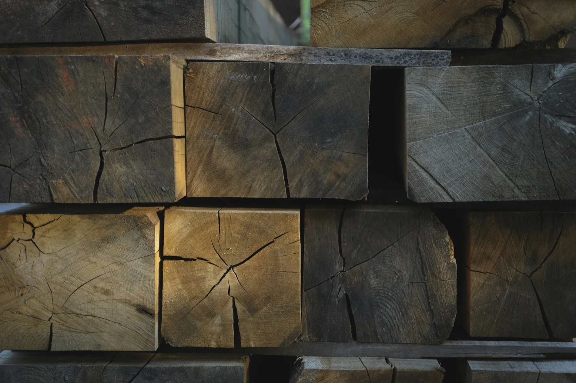 Dark weathered beam ends, each one split along the grain