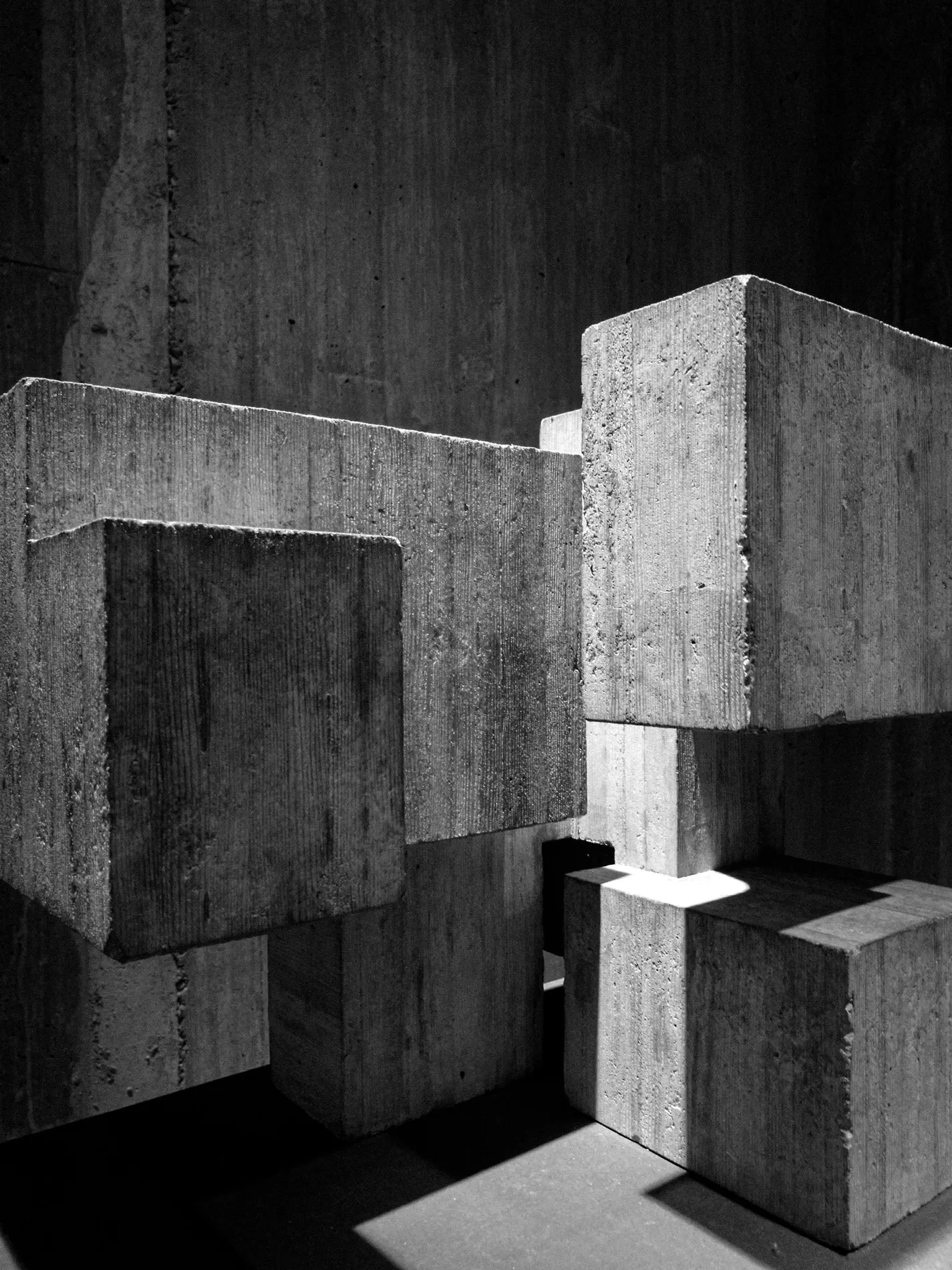 Cast concrete blocks set down in a row, one lifted clear of the others