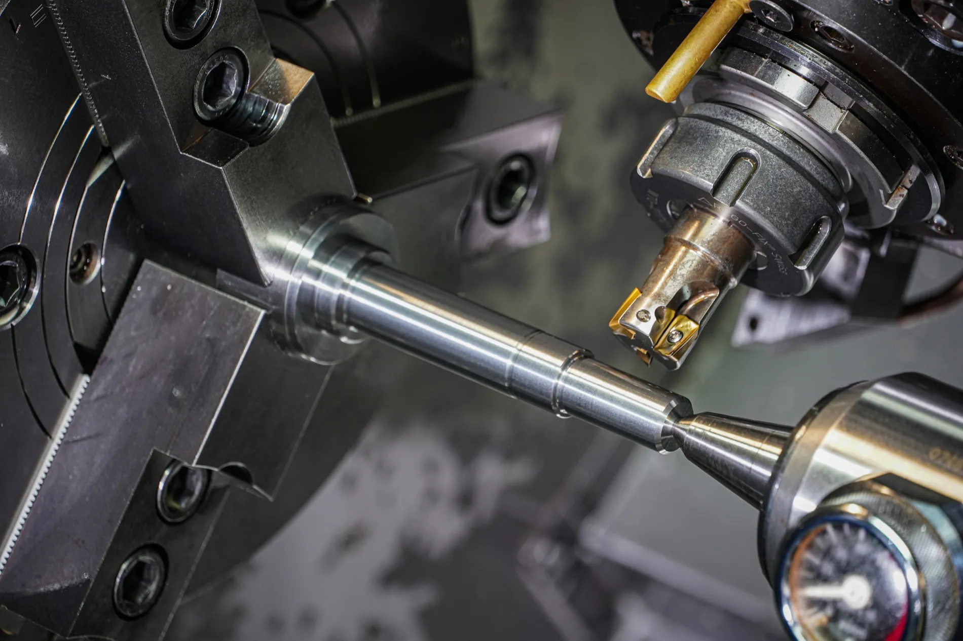 A cutting tool taking metal off a bar in a lathe