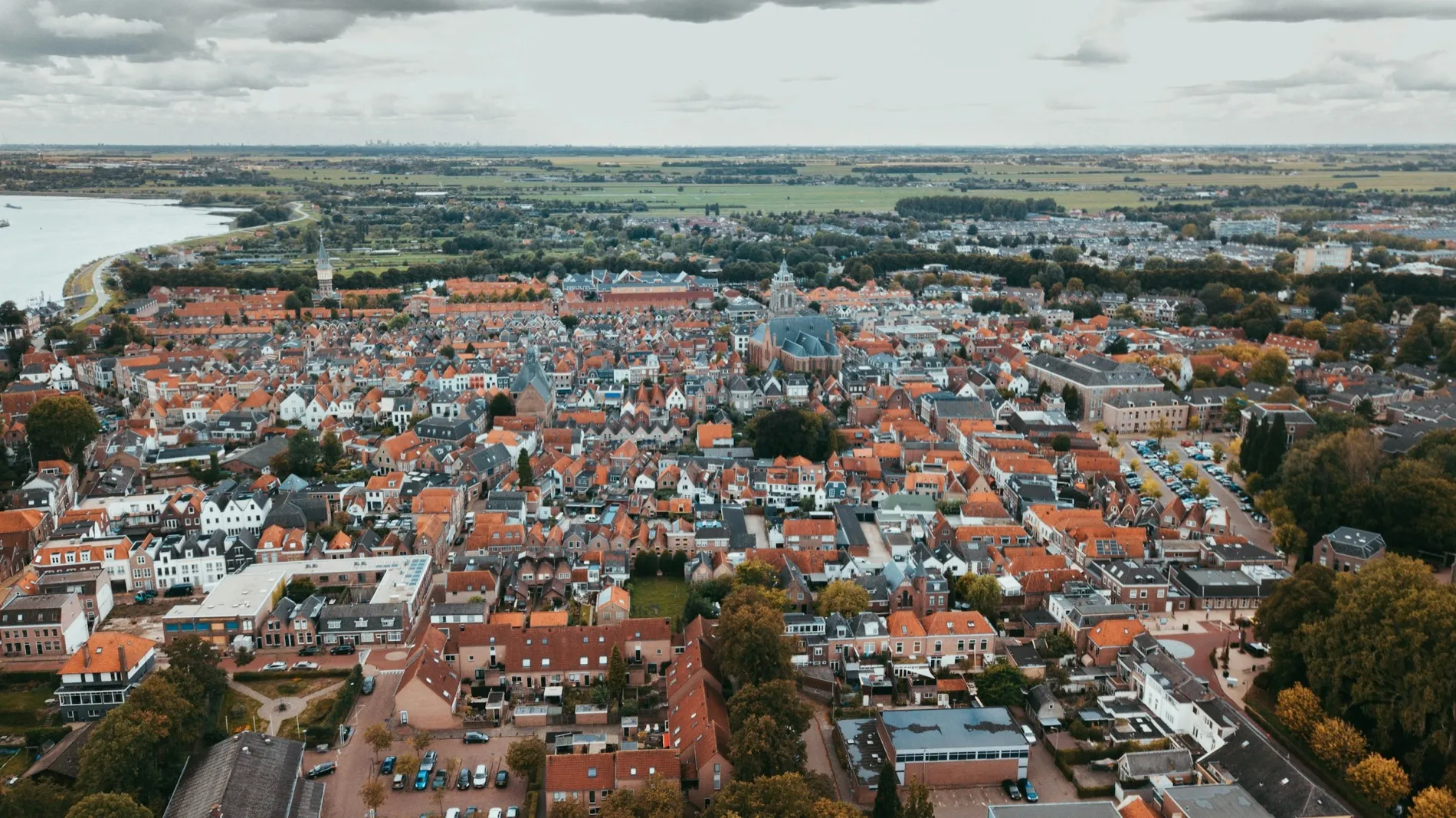 Luchtfoto van een dicht bebouwde Nederlandse stadskern met honderden pannendaken naast elkaar.