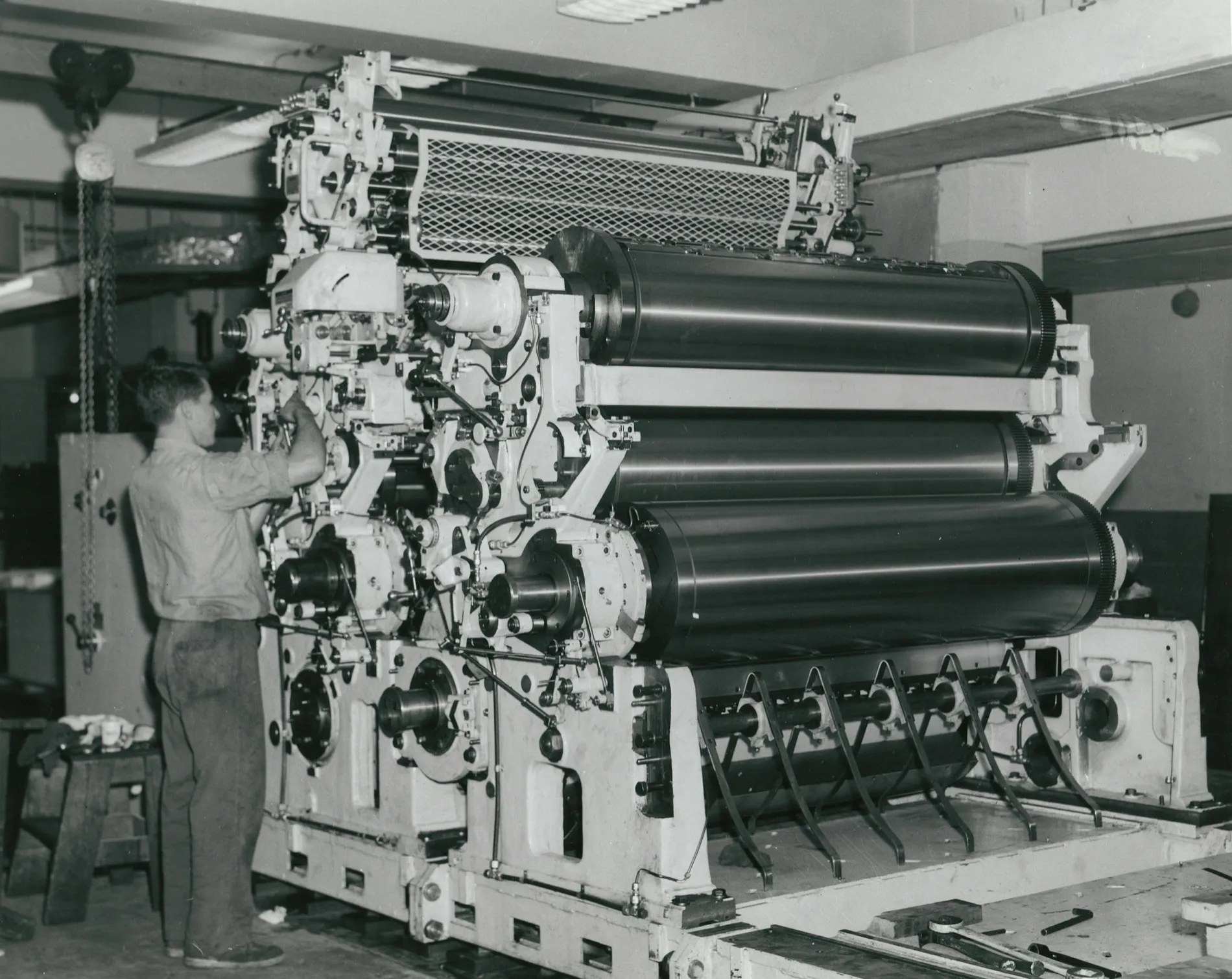 An offset press seen end on, an operator small beside it