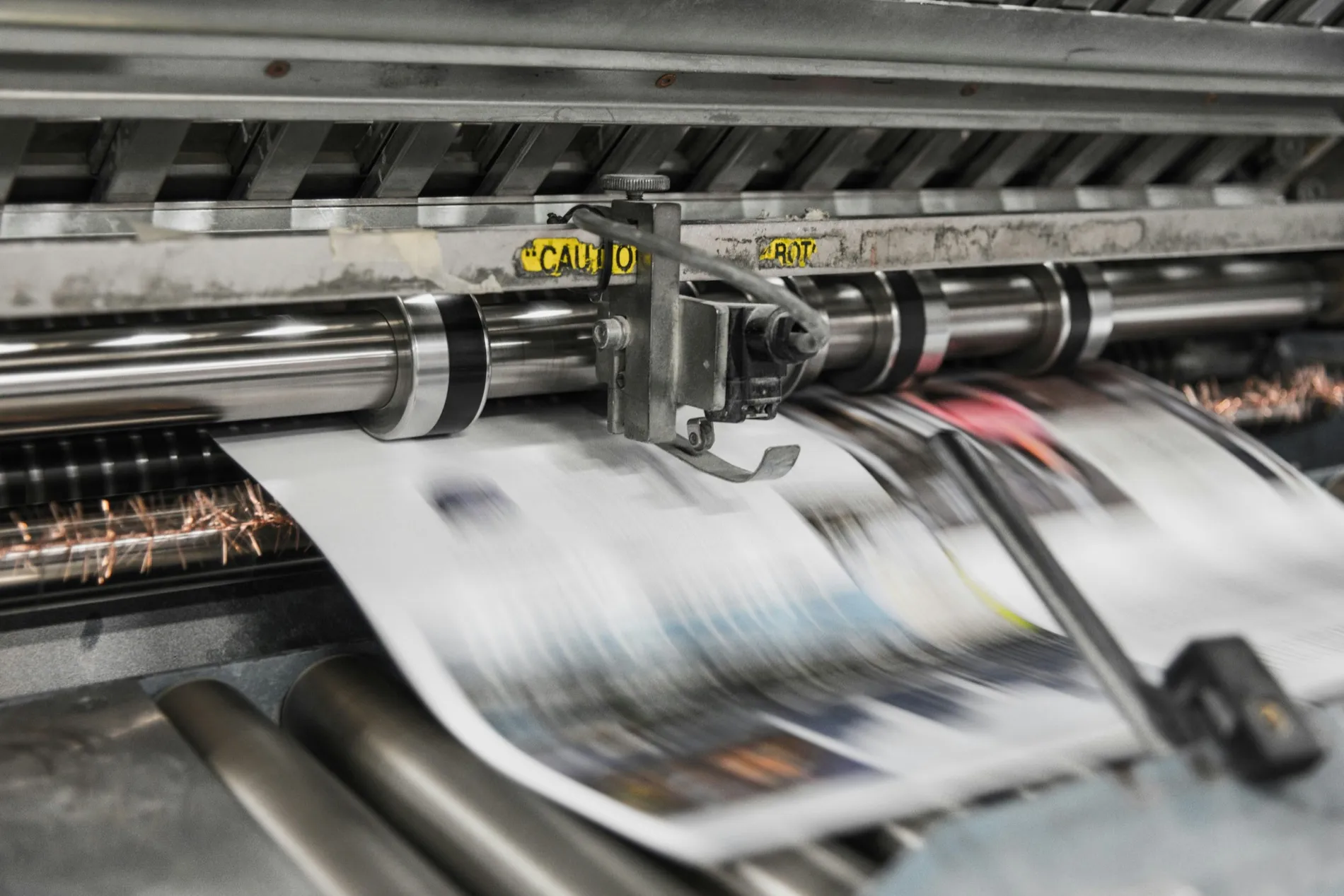 Printed sheets running through an offset press at speed